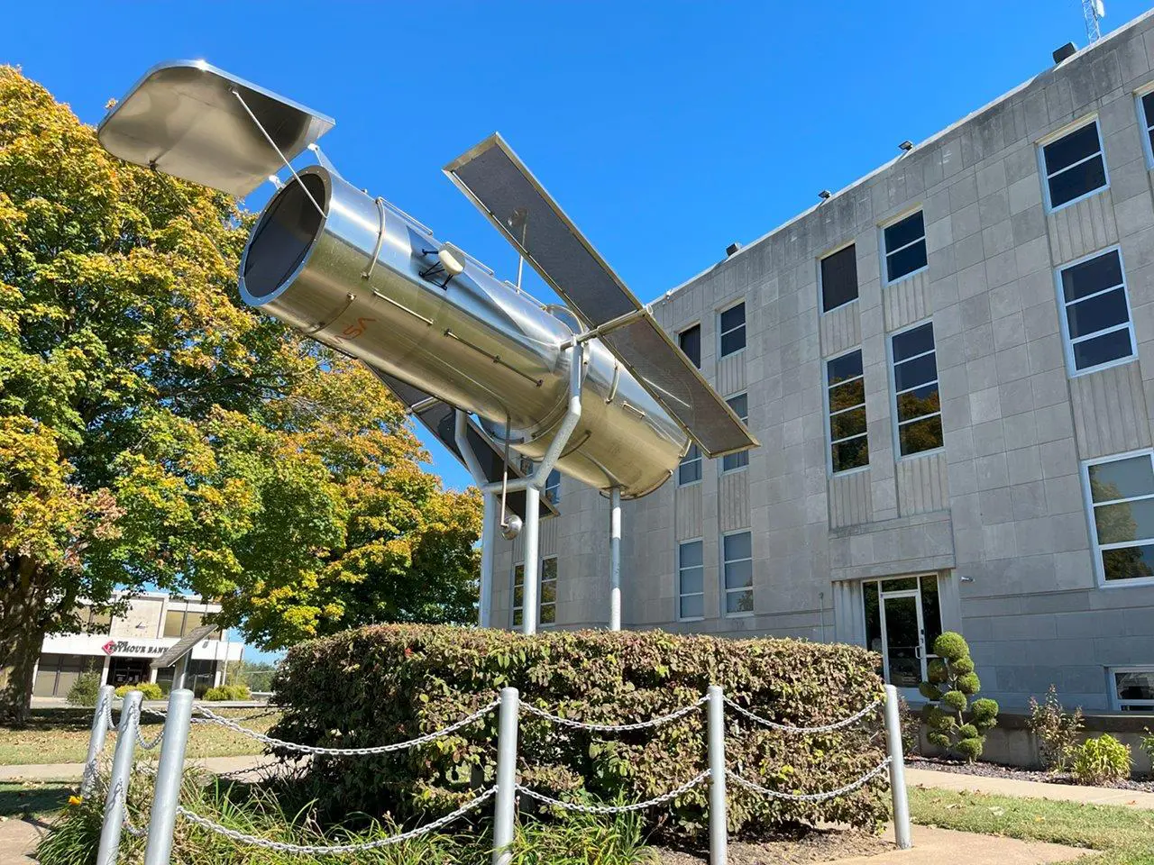 A building with trees and bushes in front of it