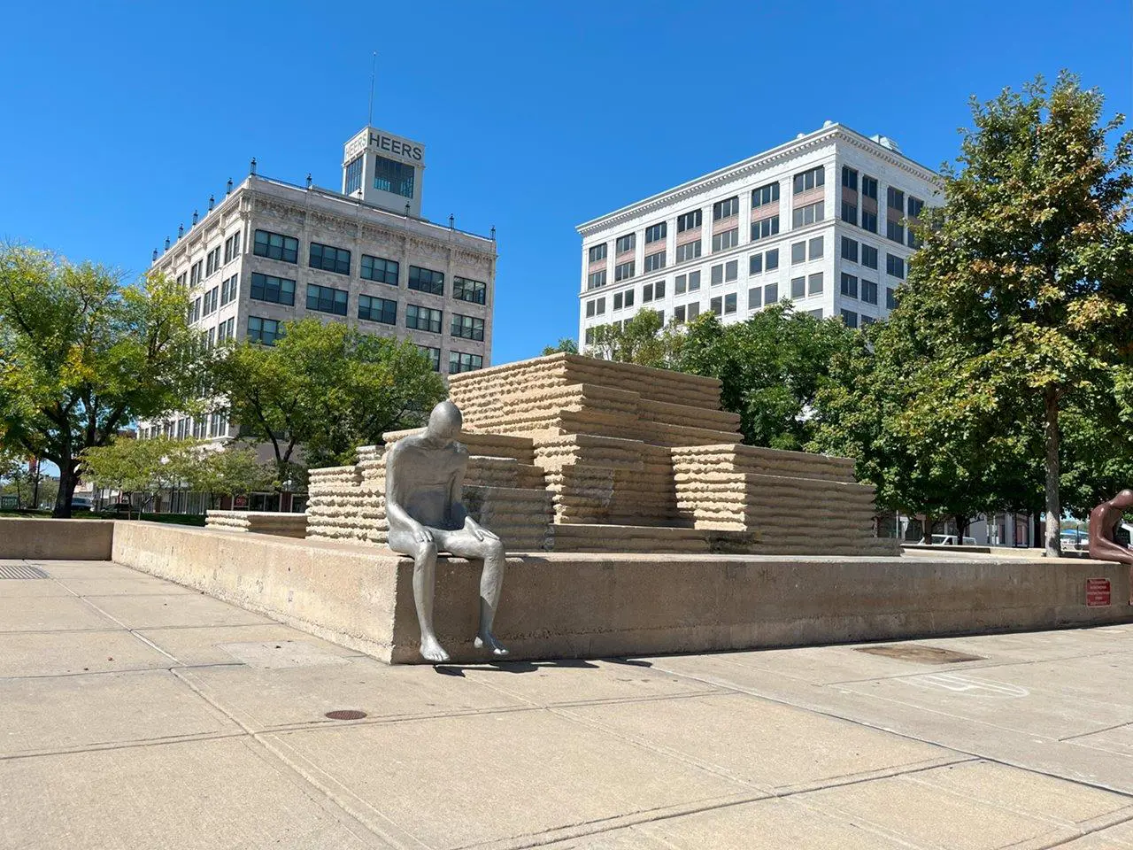 A statue of a man sitting on top of a pile of bricks.